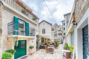 an alley in an old town with tables and chairs at Apartments & Rooms Dujam in Split