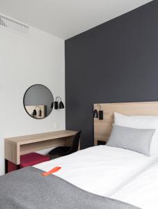 a bedroom with a bed and a desk and a mirror at Citybox Bergen City in Bergen