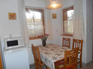 a kitchen with a table and chairs and a microwave at Vendégmarasztaló Porta in Szalafő