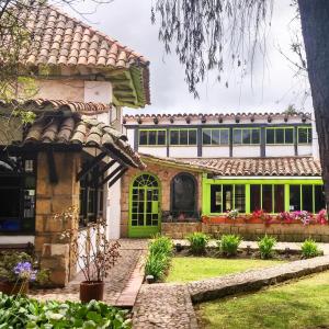 una casa con puertas verdes y un patio en Posada Cafe La Huerta, en Guasca