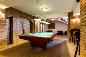 a pool table in a room with a brick wall at Pensiunea Gentiana in Bran