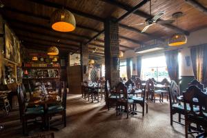 a dining room with tables and chairs in a restaurant at Merry Pebbles Resort in Sabie