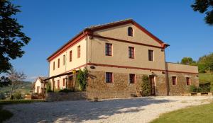 a large brick building on a gravel road at Casa Montale in Montecarotto