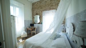 a bedroom with a bed with a white canopy at Locanda Garzelli in Quercianella