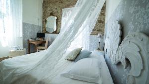 a white bed with a canopy in a bedroom at Locanda Garzelli in Quercianella