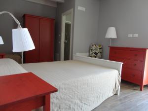 - une chambre avec un lit blanc et une commode rouge dans l'établissement Il Giglio Casa Albergo, à Rotondella
