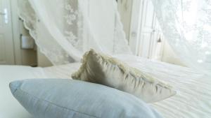 a white bed with a pillow and a window at Locanda Garzelli in Quercianella