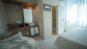 a bedroom with a bed and a bathroom with a sink at Locanda Garzelli in Quercianella