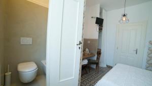 a small bathroom with a toilet and a bed at Locanda Garzelli in Quercianella