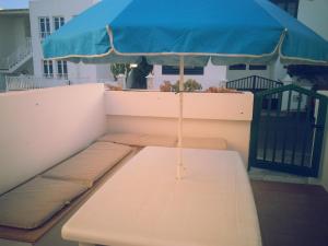 a bench with a blue umbrella on a balcony at La casita de Esteban in Arrieta