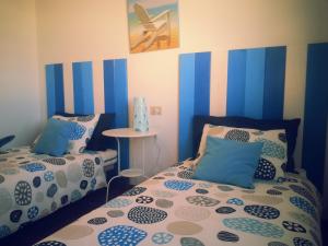 two beds in a room with blue and white stripes at La casita de Esteban in Arrieta
