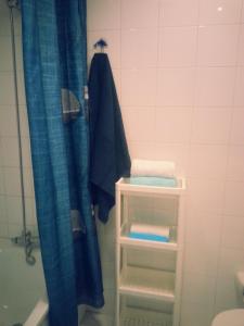 a bathroom with a blue shower curtain and a towel at La casita de Esteban in Arrieta +18 photos