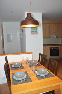 a dining room table with plates and wine glasses at Apartament Esterri Centre in Esterri d'Àneu +15 photos