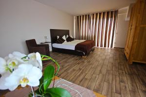 a bedroom with a bed and a wooden floor at Kaiser´s Weinland Hotel in Hammelburg