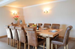 a dining room with a wooden table and chairs at Taigh na Mara in Kames