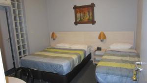 Cette chambre comprend 2 lits et une horloge murale. dans l'établissement Hotel Belvedere, à Bruxelles