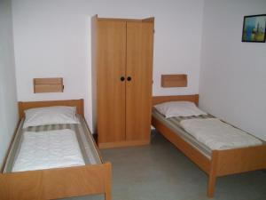 una camera con due letti e un armadio di Jugendherberge Karlsruhe a Karlsruhe