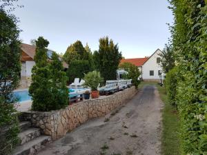 a stone retaining wall next to a swimming pool at Mandel Camping in Paloznak