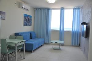 a living room with a blue couch and a table at Short Term Apartment Tel Aviv Bat Yam 413 in Bat Yam