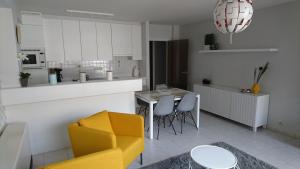 eine Küche und ein Wohnzimmer mit einem gelben Stuhl und einem Tisch in der Unterkunft SeaWind in Middelkerke