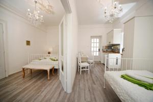 a white room with two beds and a table at Öreg Malom Apartmanház in Bogács