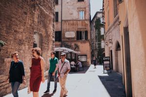 een groep mensen die op straat lopen bij Hotel Fortuna in Perugia