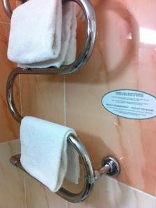 a towel rack with white towels in a bathroom at Les Palmiers in Fréjus