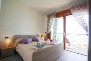 - une chambre avec un lit et une grande fenêtre dans l'établissement Oleandri Dream, à Argegno