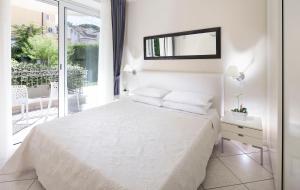 a white bedroom with a bed and a balcony at Residence Hamilton in Riccione
