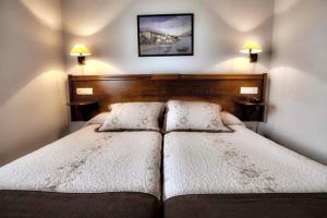 a bedroom with a large bed with two pillows at Hotel & Spa Villa de Mestas in Cangas de Onís