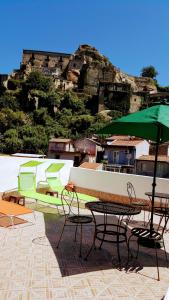 a group of chairs and tables and an umbrella at Albergo Diffuso Borgo Santa Caterina "Quartire Hebraic" in Castiglione di Sicilia