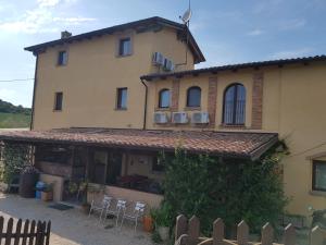 a large house with chairs and tables in front of it at La Locanda dei Cavalieri Affittacamere in Lugagnano Val dʼArda