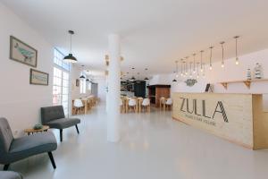 un vestíbulo con sillas y mesas y un restaurante en Zulla Nazaré`s Surf Village, en Nazaré