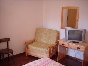 a room with a chair and a tv on a table at B&B Passo del Cerreto in Cerreto Laghi