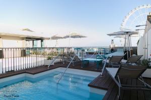 a swimming pool with chairs and a ferris wheel at Room Mate Valeria in Málaga