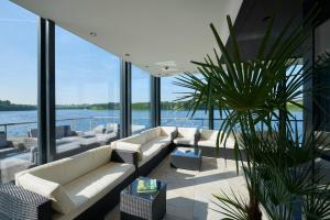 ein Wohnzimmer mit Sofas und Blick aufs Wasser in der Unterkunft Beverly Weekend in Bütgenbach