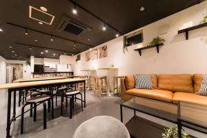 a bar with a couch and a table and chairs at KIZUNA HOTEL Gojo Kiyomizu-dera Kamogawa in Kyoto