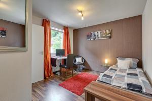 ein Schlafzimmer mit einem Bett und einem Schreibtisch mit Computer in der Unterkunft Hotel Alte Post in Calw