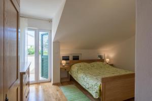 a bedroom with a bed and a desk and a window at Stara Kuća Apartments in Šimuni