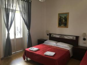 una camera da letto con un letto con una coperta rossa e una finestra di Vertex Suite a Roma
