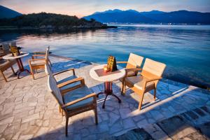 een groep stoelen en tafels naast het water bij Luxury Sea Residence by Kristina in Tivat