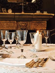 uma mesa com copos e talheres sobre uma mesa em B&B Mugnos Charme Living em Licodia Eubea