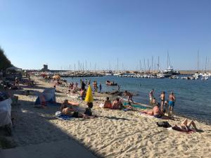 a group of people on a beach near the water at Appartamento Lungomare in Marciana Marina