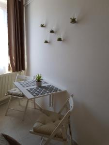 a table and a chair with plants on a wall at Valentin ház in Szentendre