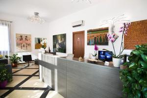 an office with a reception desk and some plants at Verona Class ApartHotel "Residenze del Cuore" in Verona