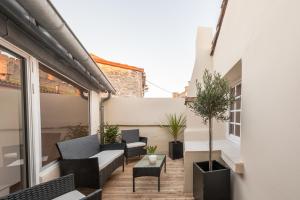 - un balcon avec des chaises et une table dans un bâtiment dans l'établissement Cité Chic, à Carcassonne