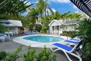 a swimming pool with lounge chairs and a house at Center Court-Boutique Old Town Lodging in Key West