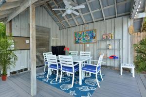a patio with a table and chairs and a ceiling fan at Center Court-Boutique Old Town Lodging in Key West