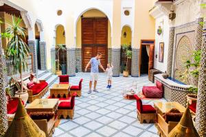a man and a child standing in a courtyard at Riad-Boutique Borj Dhab Fez in Fez