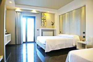 een hotelkamer met 2 bedden en een raam bij Foglie D' Acqua in Bisceglie